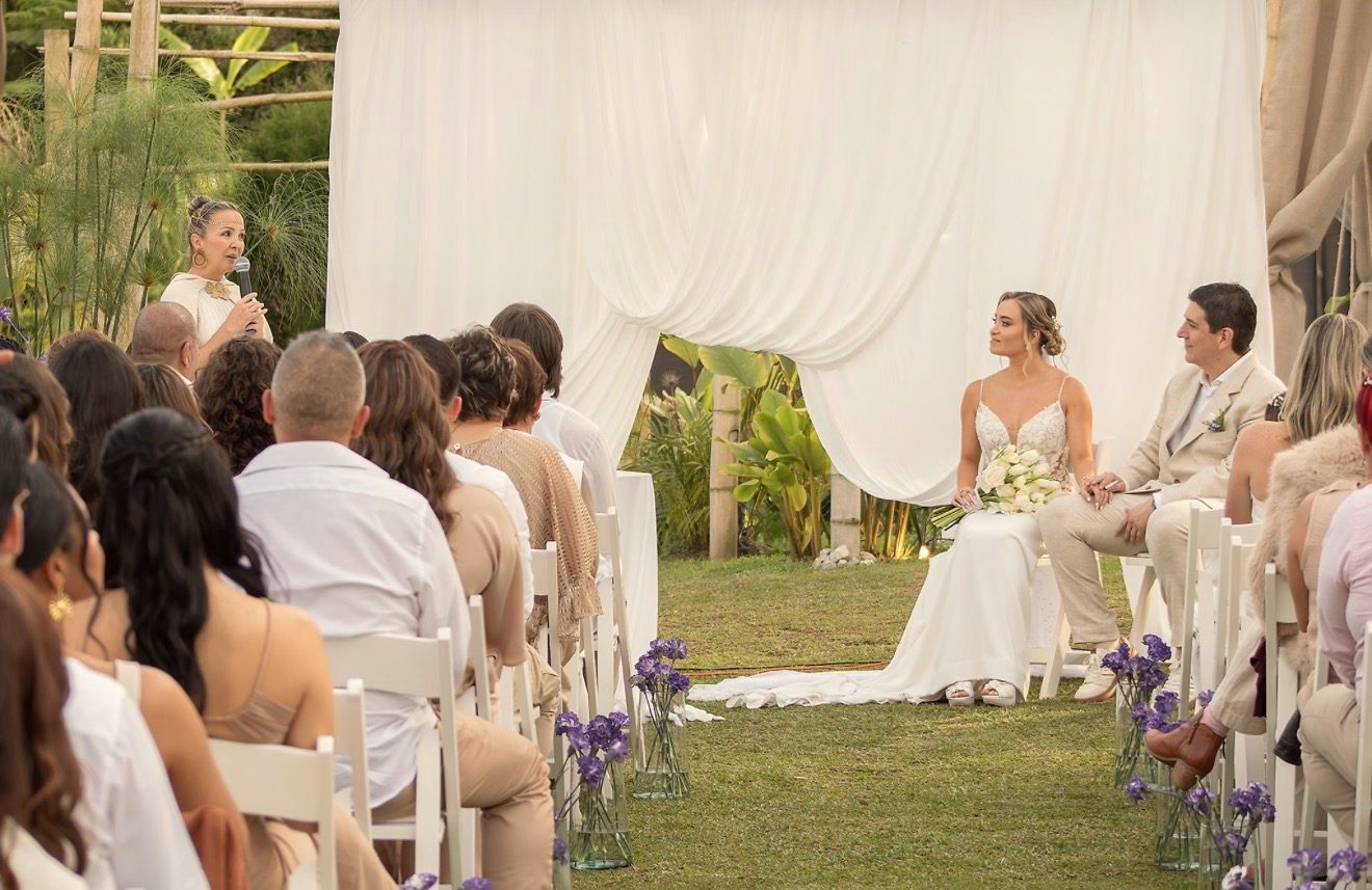 Ceremonia al aire libre con cortinas blancas y flores lila