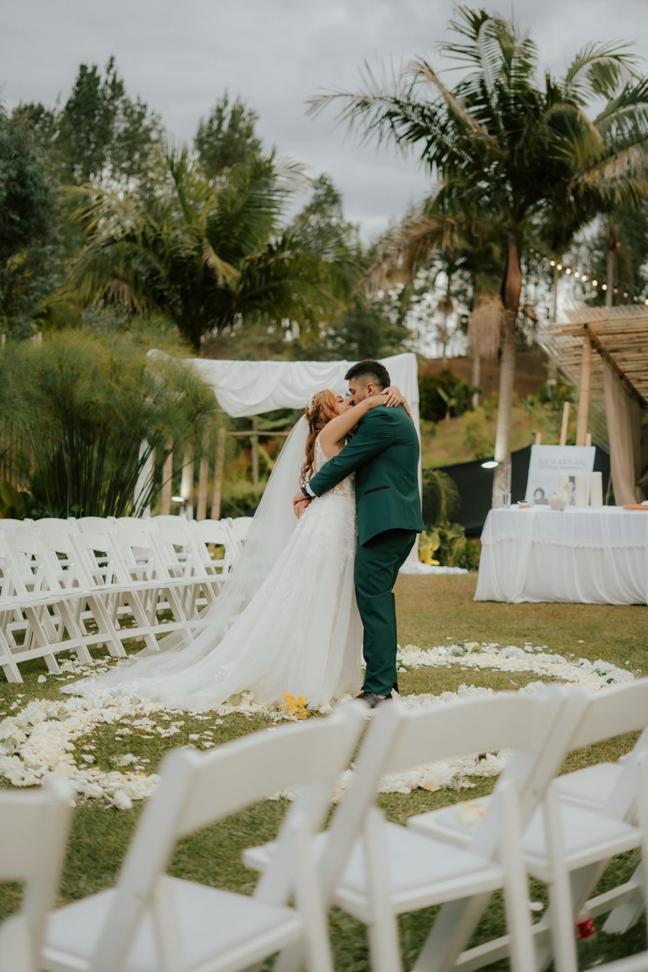 Beso de los novios entre las sillas de la ceremonia